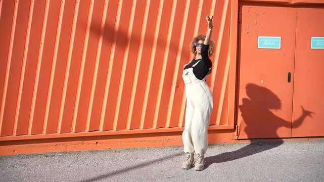 A chic casual fashion photoshoot set against a lively and vibrant orange background