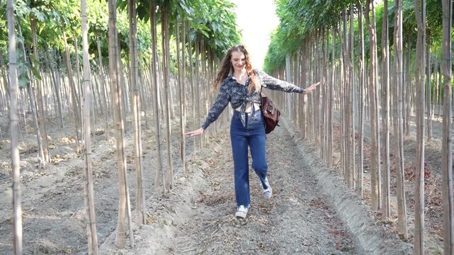 A woman is enjoying the serene atmosphere while walking through a beautiful vineyard pathway