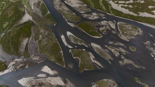 Aerial view of the braided glacial river contrasting with the stark landscape, creating a mesmerizing pattern from above, Selfoss, Iceland.