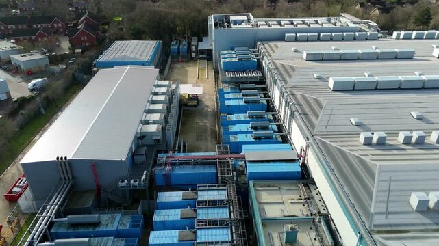 Aerial view of Colt Data Centre Services, a sprawling industrial landscape with structures, machinery, and rooftops, Welwyn Garden City, United Kingdom.