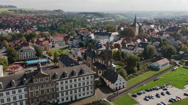 Aerial view of the Baroque Jesuit Church and Mauritius Gymnasium in Buren, Germany, surrounded by a historic townscape.