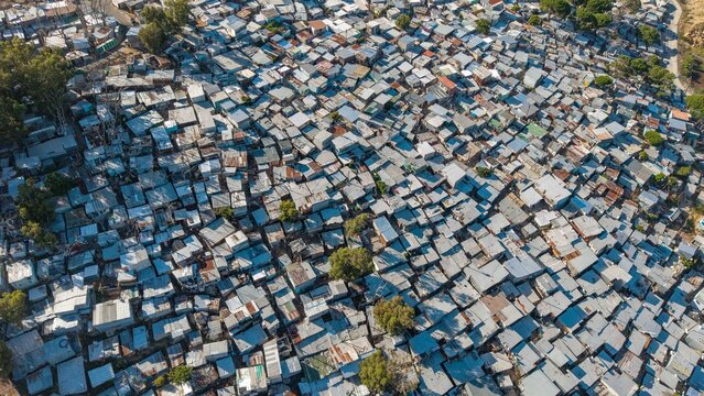 Aerial view of corrugated iron roofs glinting under the sun, creating a textured mosaic across the landscape, Cape Town, Western Cape, South Africa.