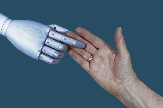 Altenpflege in der Zukunft. Eine Roboterhand und eine Menschenhand. Roboter und Mensch ber&uuml;hren sich