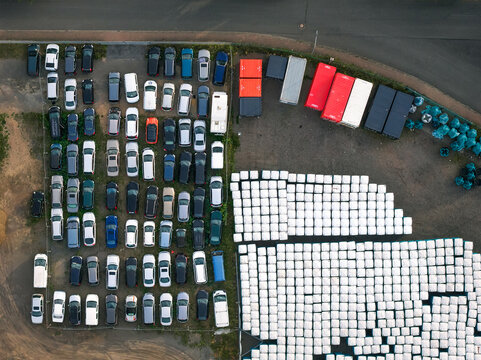 Aerial view of organized chaos as vehicles, containers, and stacked objects create a vibrant patchwork of color and form, Mullenbach, Rhineland-Palatinate, Germany.