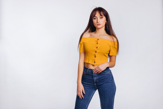young woman in jeans and blouse posing on white background. stud