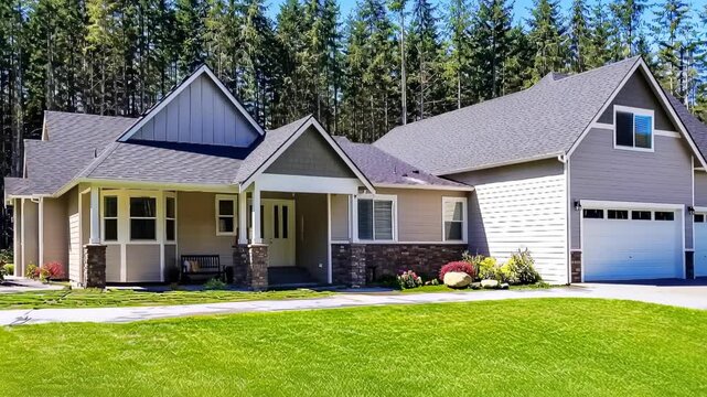 Ground level smooth dolly shot approaching a modern suburban house surrounded by lush forest trees