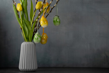 Colorful eggs and tulips in a vase create a spring atmosphere for Easter celebration at home