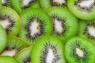 Slices of fresh kiwifruit spread on a flat surface showing the inside of each piece