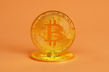 Bitcoin gold coins close up isolated on orange background