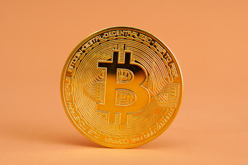 Bitcoin gold coin close up isolated on orange background