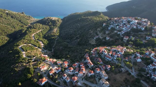 Aerial Cinematic Flyover of Chora Old Town Alonissos &mdash; Traditional Greek Village Architecture with Stone Houses, Terracotta Roofs and Aegean Sea Panorama, Sporades Greece
