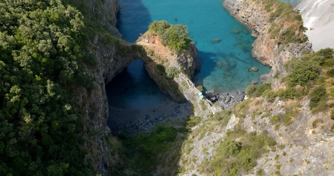 Aerial closeup of the Arcomagno of San Nicola Arcella on the Tyrrhenian coast of Calabria, Italy. It is a geological formation located along the beautiful Gulf of Policastro. It has a crystalline sea.