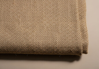 Closeup of folded beige burlap fabric texture detail