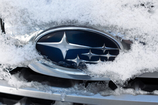 Subaru logo covered with snow in winter. Winter driving of Subaru