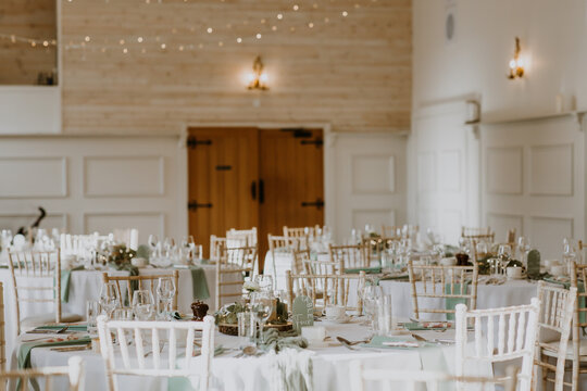 White and cream rustic table settings ready for a barn wedding with chiavari chairs