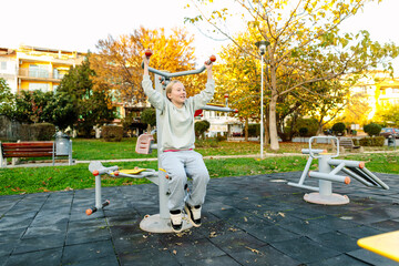Teenage girl exercising on outdoor fitness equipment in park, active lifestyle, healthy childhood, physical activity, sport and wellness concept

