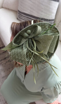 Elegant green fascinator on young caucasian female for formal events &ndash; millinery, fashion boutiques, event planners concept of
