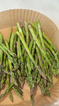 Fresh asparagus on rustic paper plate: timelapse of natural arrangement transformation