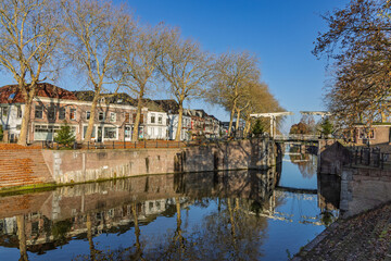 Fototapeta premium Picturesque view of the historic canal and drawbridge in Vreeswijk, Nieuwegein, with traditional houses and autumn leaves reflecting in the water.