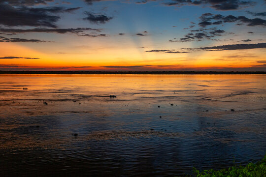 Paisagem tropical de rio com pequena canoa ao centro e c&eacute;u de fim de tarde - Urucurituba, munic&iacute;pio do estado do Amazonas - Brasil 2
