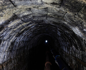 Obraz premium Tunnel in Sete Cidades, San Miguel, Azores. Rough stone walls and dim lighting.