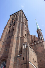 Gothic brick church tower against clear blue sky