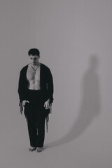 Unadorned monochrome image features lone man standing contemplatively