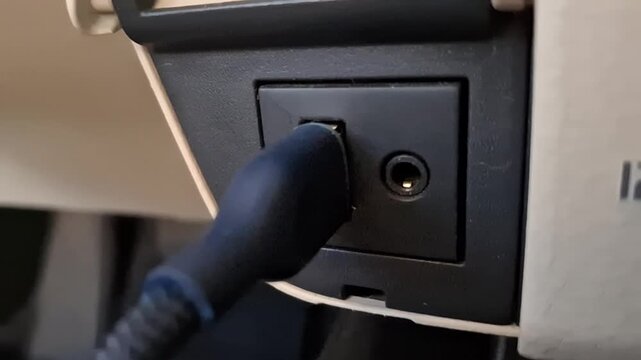 Close-up of inserting a USB cable into a car dashboard media port.