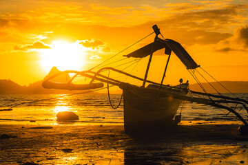 fishing boat on the beach during sunrise