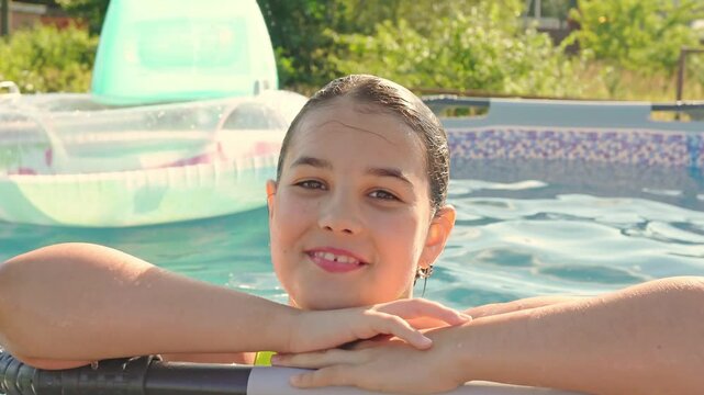 Joyful child enjoying sunny pool day with inflatable floaties in backyard