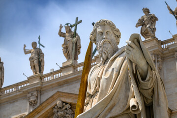 Obraz premium A statue of Saint Paul (by Adamo Tadolini, 1838) in front of Saint Peter's Basilica in the Vatican, Rome, Italy.