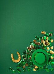 St. Patrick's Day Leprechaun Hat, Gold Coins, Shamrocks and Party Favors on Green Background.