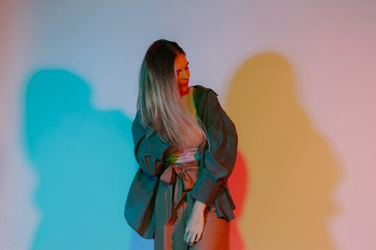 Woman posing in studio with colorful light projection