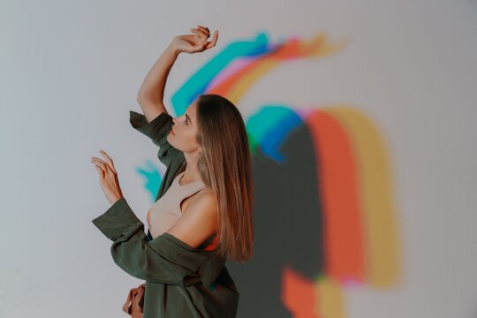 Woman expressing body language in colored light projection