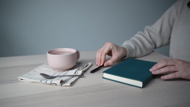 Opening notebook on minimal workspace with coffee cup