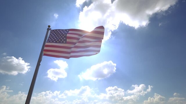 USA Flag American Flag waving on a Flagpole from a Moving Angle in front of a blue sky with clouds	