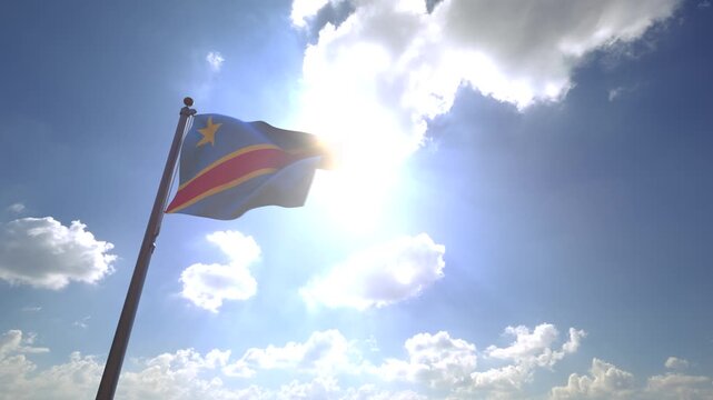 Democratic Republic of the Congo Flag waving on a Flagpole from a Moving Angle in front of a blue sky with clouds	