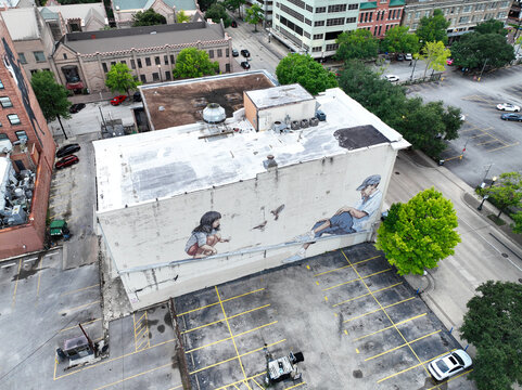 Aerial drone photograph of the &ldquo;Healthy Aging&rdquo; mural in Houston, created by renowned street artist Ernest Zacharevic. The artwork captures a heartfelt scene of a child and an older man.