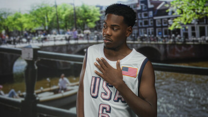 Fototapeta premium Young african american man in white sleeveless jersey clutch chest for heartattack on canal by railing; distress.