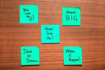 Green-Blue Motivational Sticky Notes on Wooden Surface