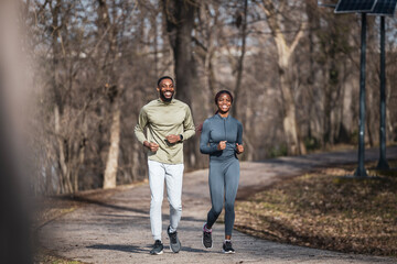 Obraz premium Happy black couple jogging outdoors in park