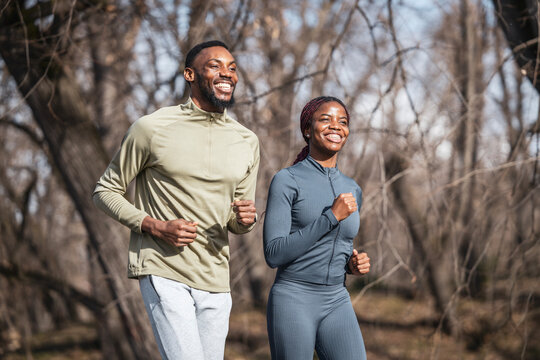 Happy african american couple running together outdoors