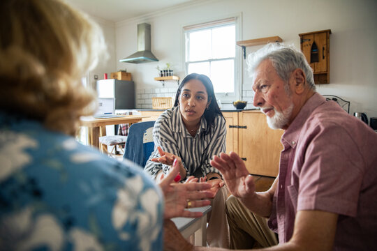 Young woman leads family care discussion with seniors at home