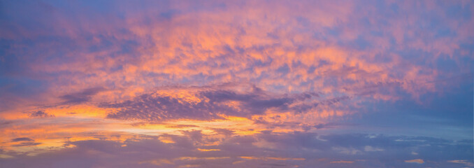 Obraz premium A beautiful sky, golden clouds in a blue sky at sunset create a natural backdrop and a wonderful evening atmosphere.