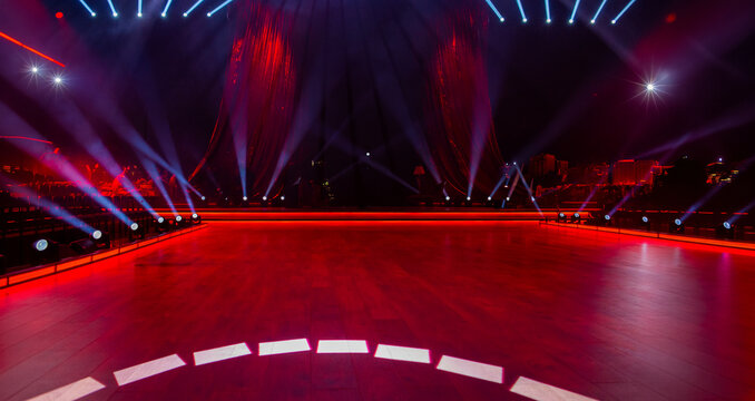 Colorful abstract background with empty concert stage with red curtains, dance floor and stage spotlights