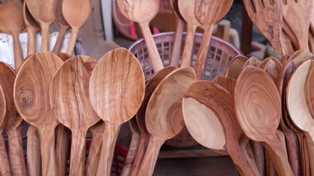 A close-up view of handmade wooden spoons with natural grain patterns, showcasing traditional craftsmanship, sustainable materials, and rustic kitchen culture.
