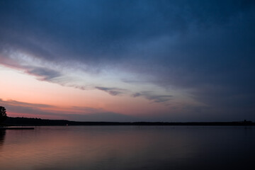 Obraz premium Serenity landscape panorama. Evening lake with dramatic sky and sunset