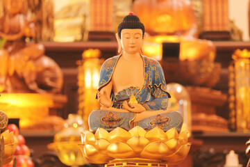 Buddha statue meditating in serene atmosphere of a dimly lit Buddhist temple interior, close up detailed shot. soft focus