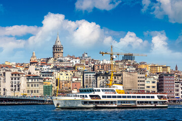 Obraz premium Passenger ferry in a gulf of the Golden Horn and Galata tower in Istanbul, Turkey
