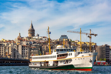 Fototapeta premium Passenger ferry in a gulf of the Golden Horn and Galata tower in Istanbul, Turkey